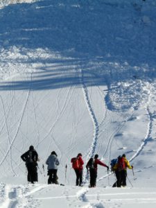 Skiers looking at avalanche on multi-day backcountry trip